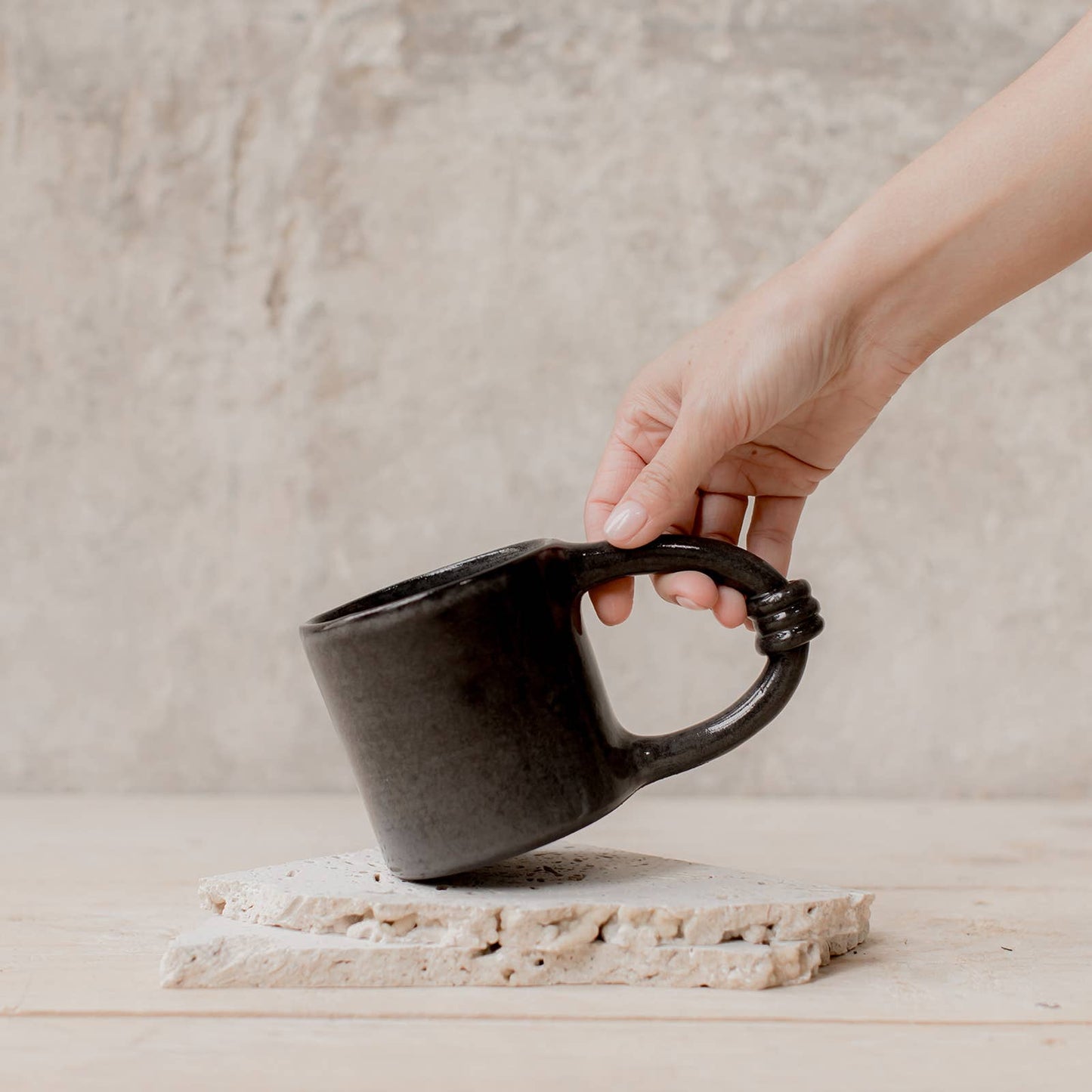 Le Maxi Mug Grande Anse Les Choses qu'on Aime Noire tenue par main